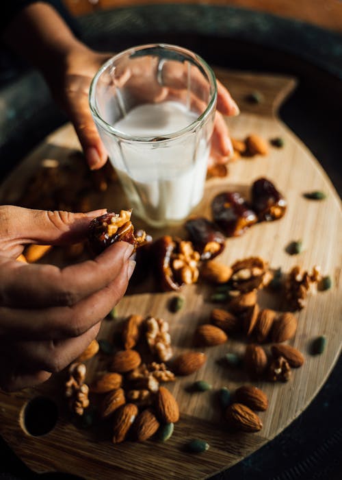 A Person Eating Nuts and Drinking Milk