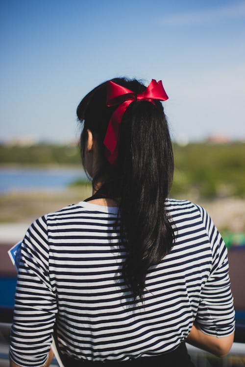 Woman in Black and White Striped Shirt With Red Ribbon in Her Hair