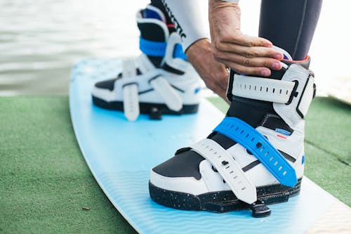 Man Clipping His Boots on a Wakeboard 