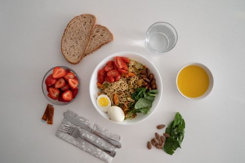 Free A balanced meal featuring a variety of healthy ingredients including noodles, eggs, almonds, strawberries, and fresh vegetables. Stock Photo