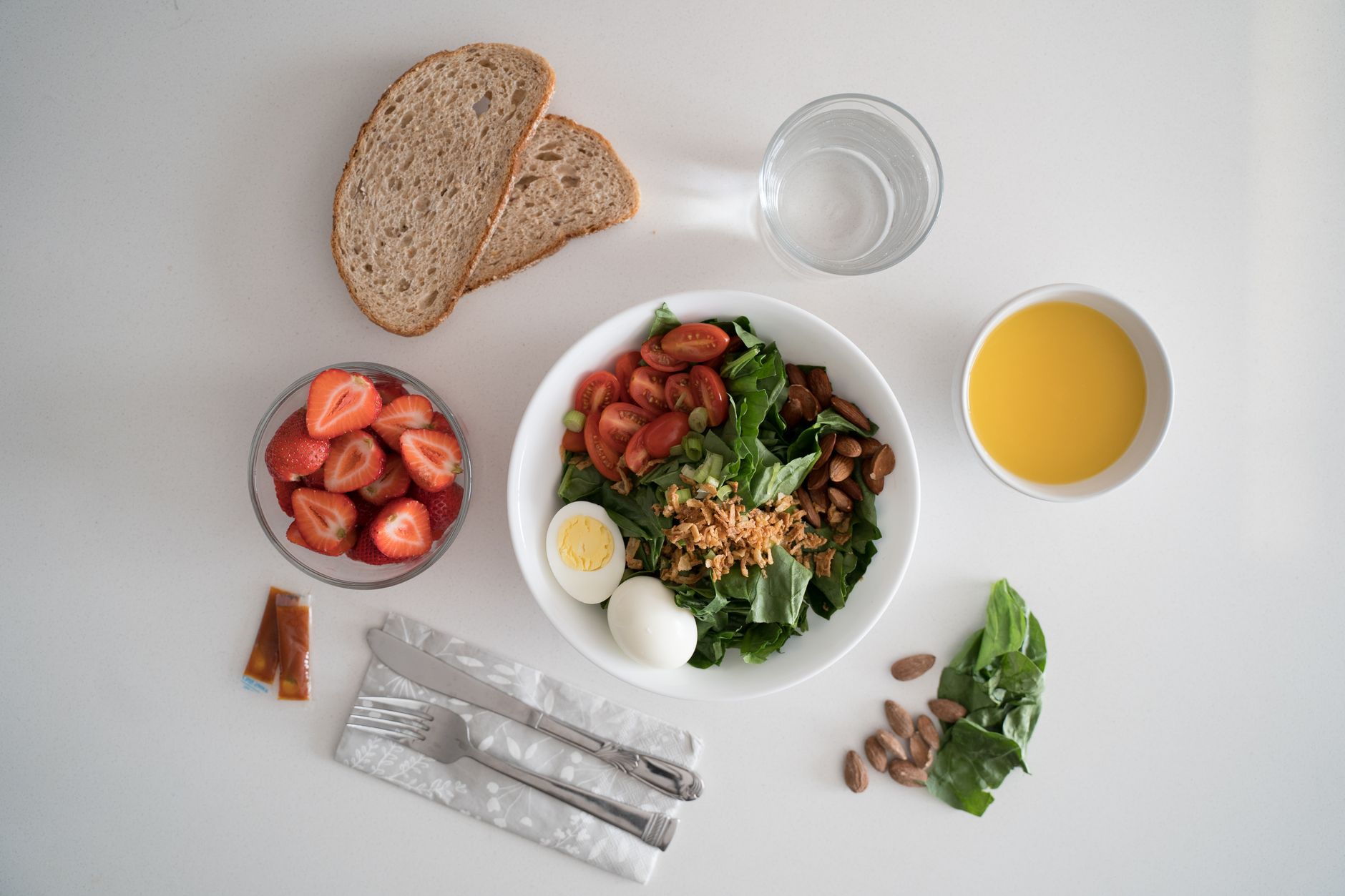 A breakfast table set with eggs, greens, bread and juice for a meal-based routine.