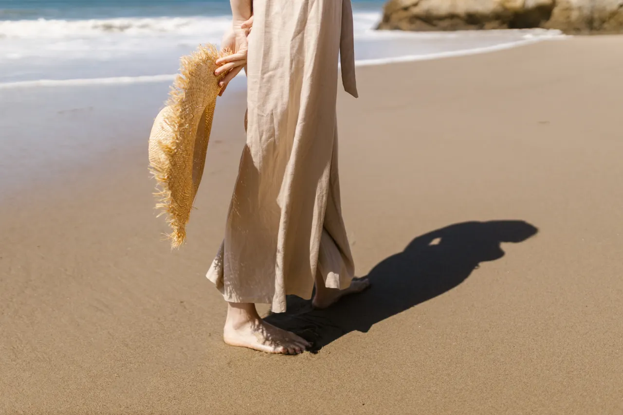 linen-pants-breezy-top-airport Woman in beige linen pants, a breathable summer airport outfit idea