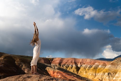 Free Woman in White Dress Standing on a Rock Stock Photo