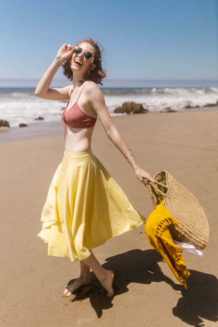 A Woman Wearing Brassiere And Yellow Skirt Standing On Shore