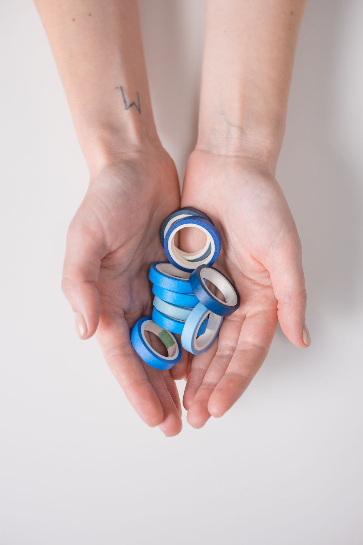 Hands holding blue gradient tapes for making duct tape cuff bracelets