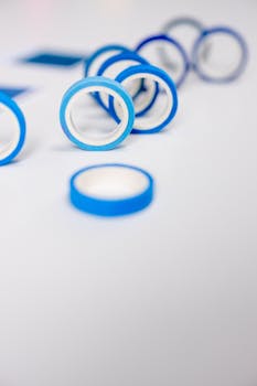 Close-up of blue tape rolls cascading on a white surface, showcasing a minimalist and modern design.