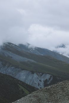 Majestic mountain range enveloped by thick white clouds, creating a serene landscape.