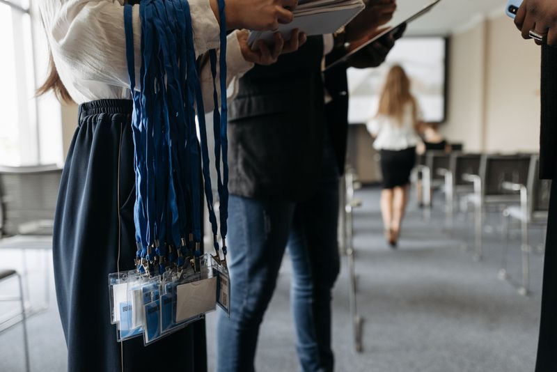 Des personnes dans une salle de conférence se préparant avec des badges et des porte-noms.