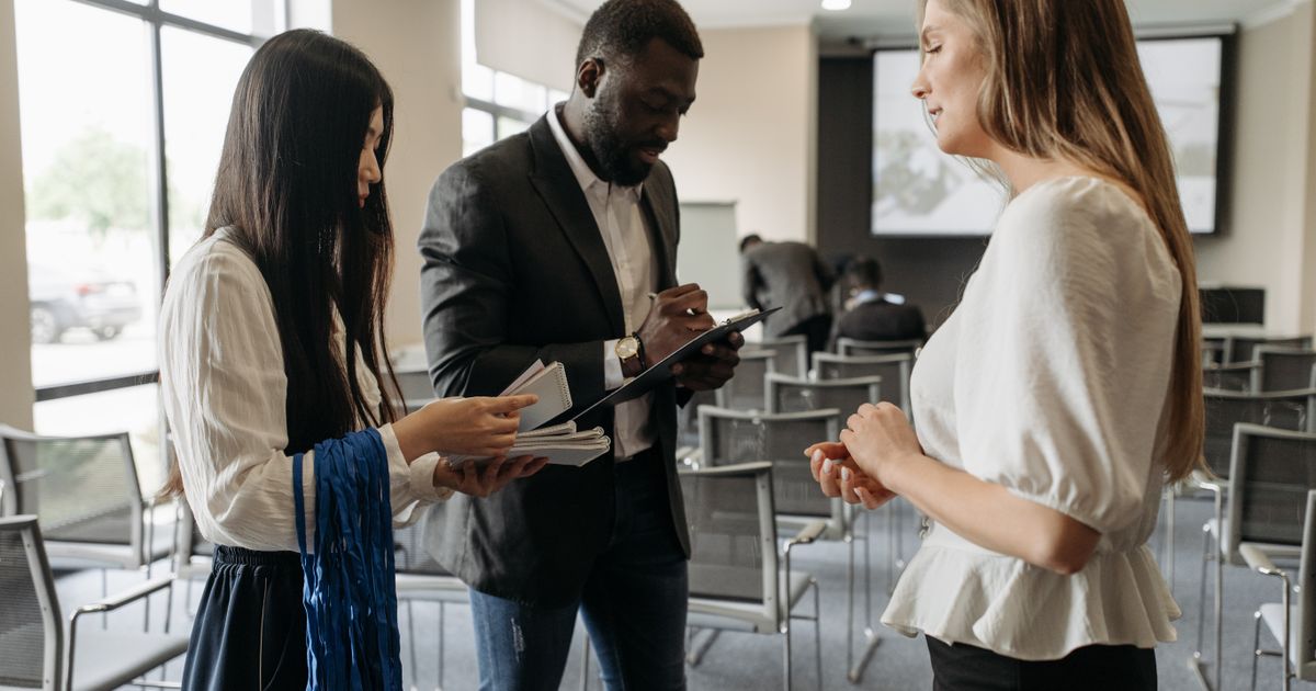A freelancer at a networking event, handing out a business card to a potential client.