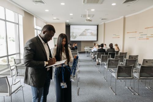Free A diverse team prepares for a business conference in a modern office setting. Stock Photo