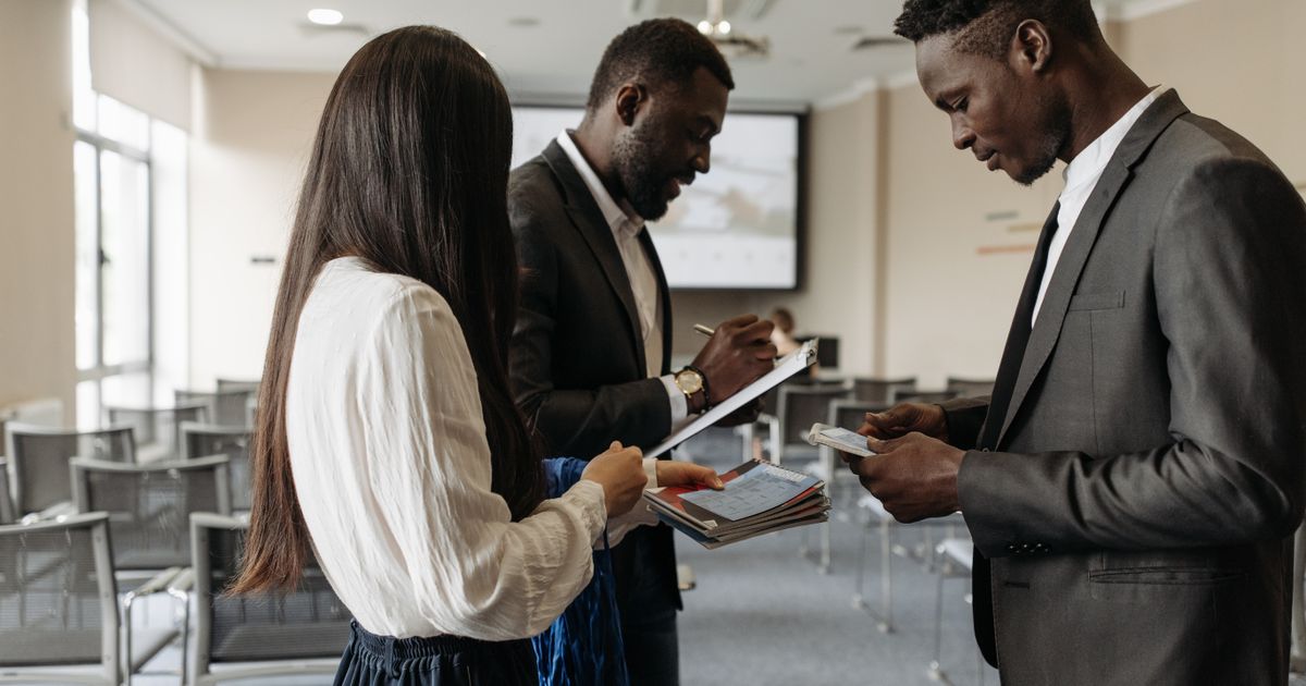 Public health professionals networking at a conference, exchanging business cards.