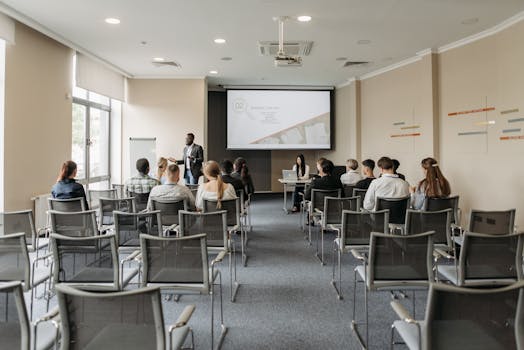 A group attending a business presentation in a modern conference room with projector.