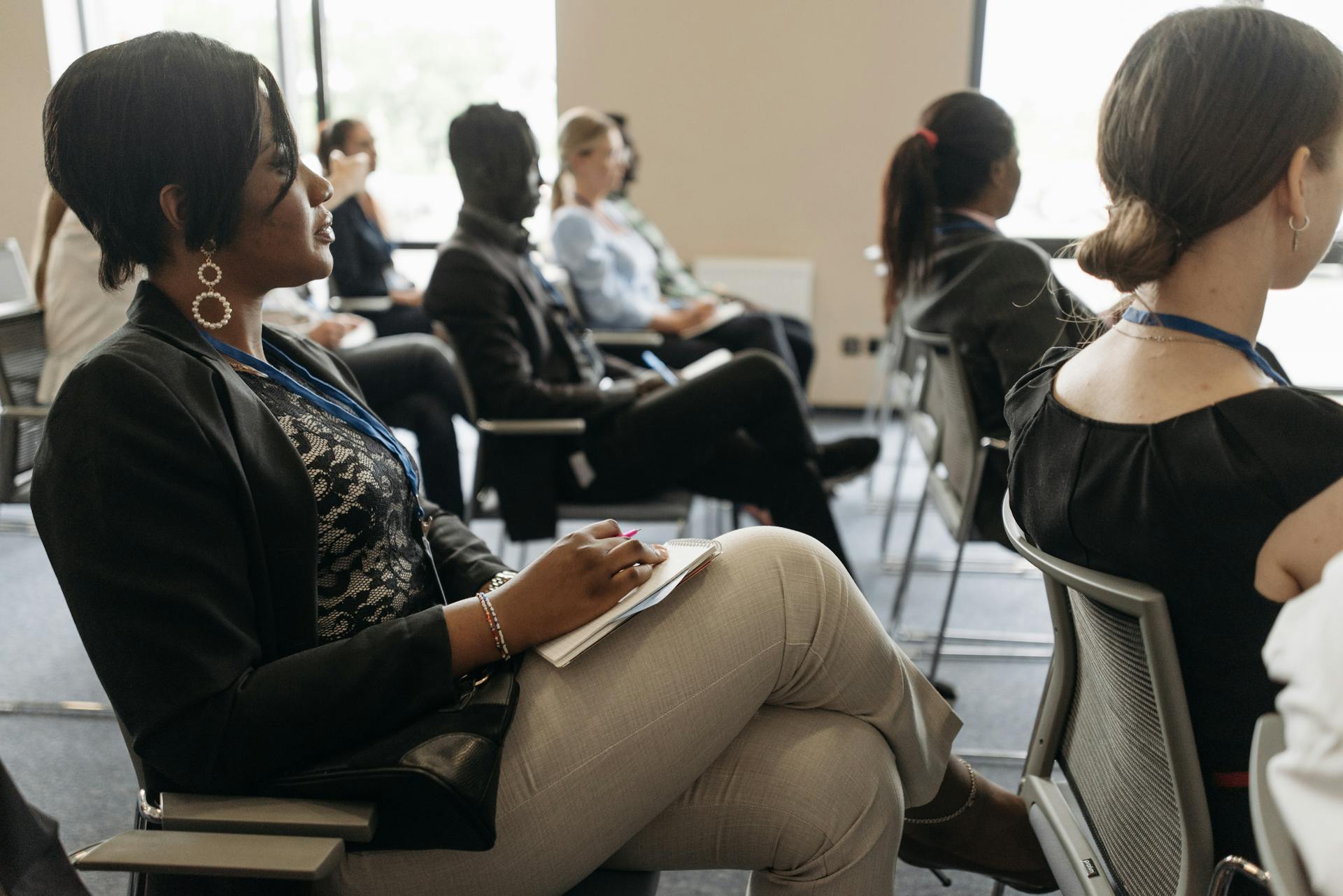 Participants attentively listening in a business conference room, highlighting diversity.