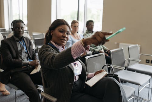 A Woman Sitting on the Chair while Pointing Finger