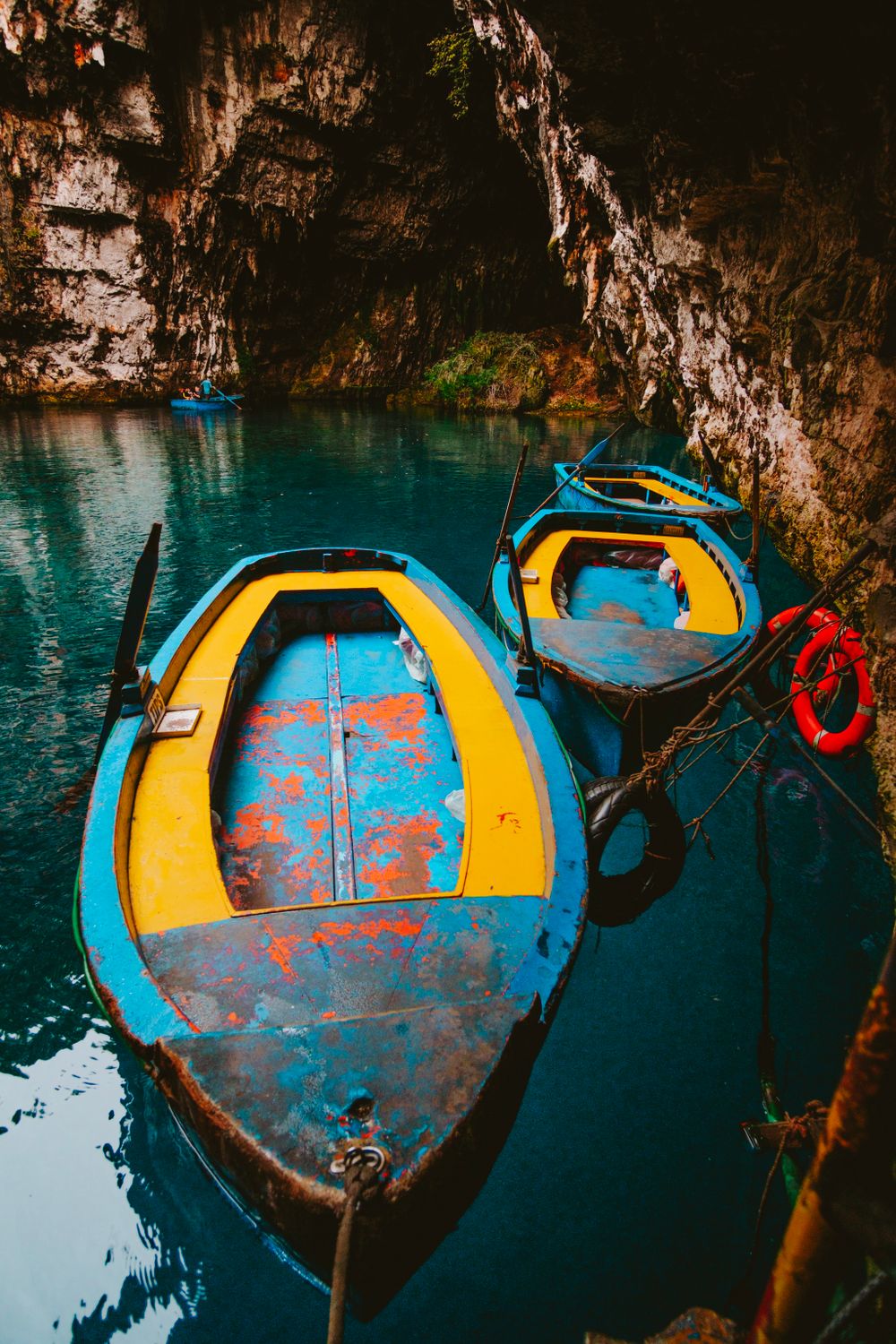 Bărci pe lacul subteran din peștera Melissani, Kefalonia, cu apă albastră