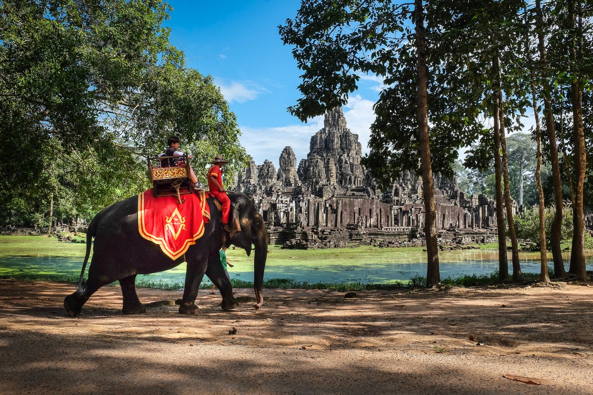 People Riding an Elephant Near the Bayon Temple