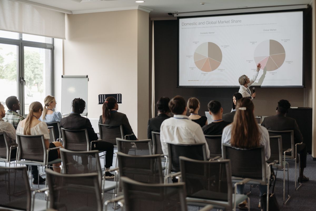 Attendees viewing a large projector screen during a business presentation
