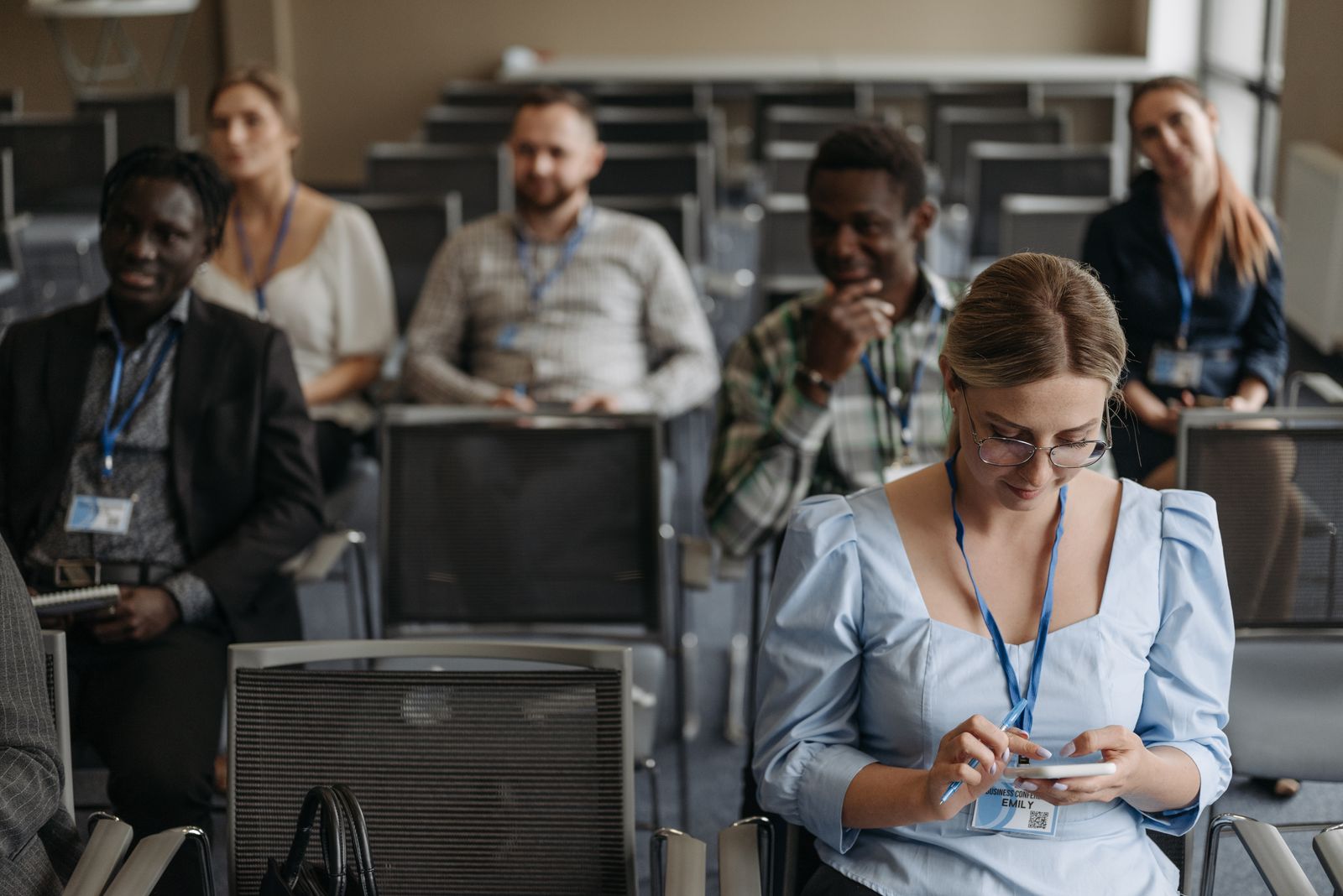 A woman using her smartphone while at a business seminar