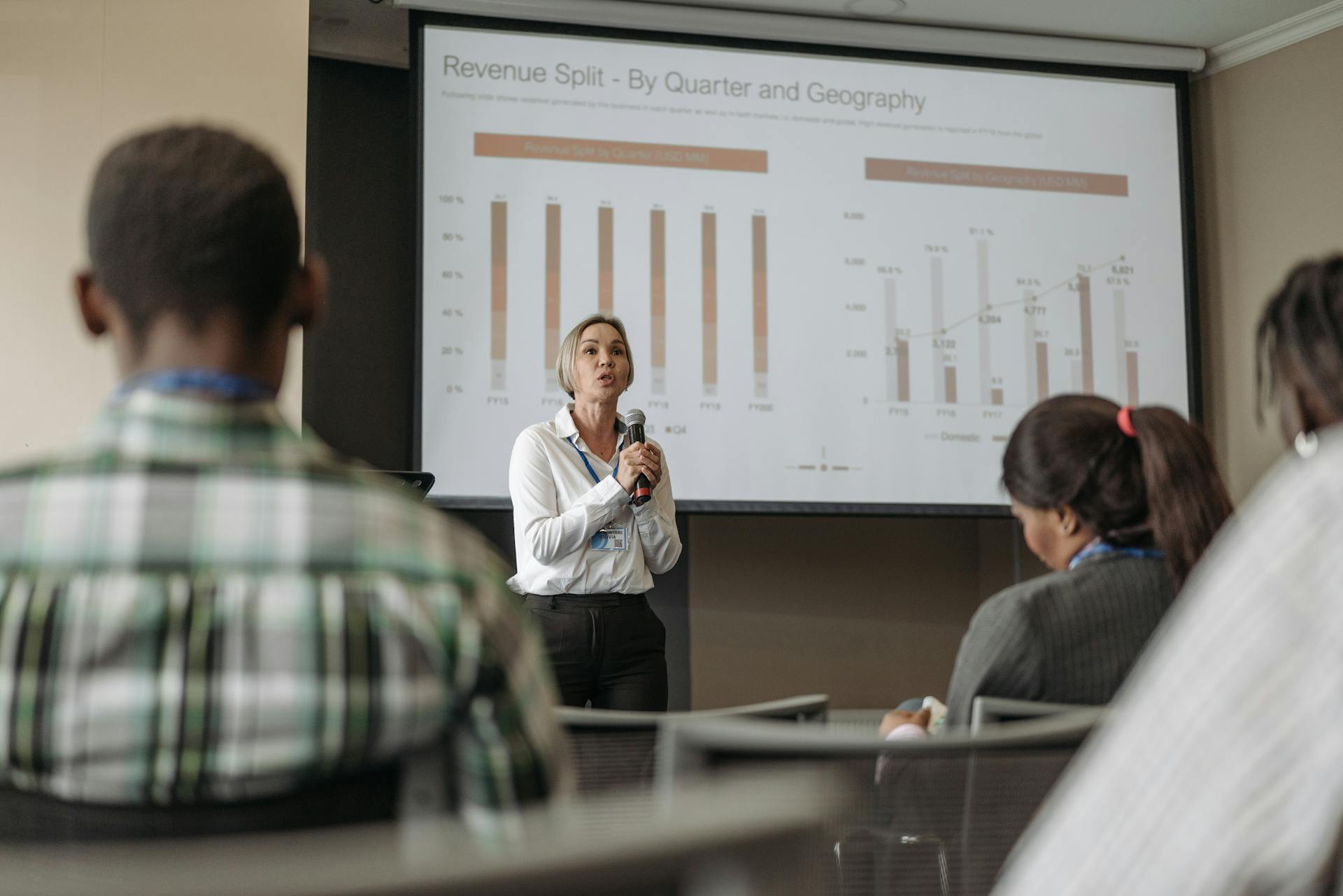 Professional presentation on revenue split by quarter and geography during a business conference.