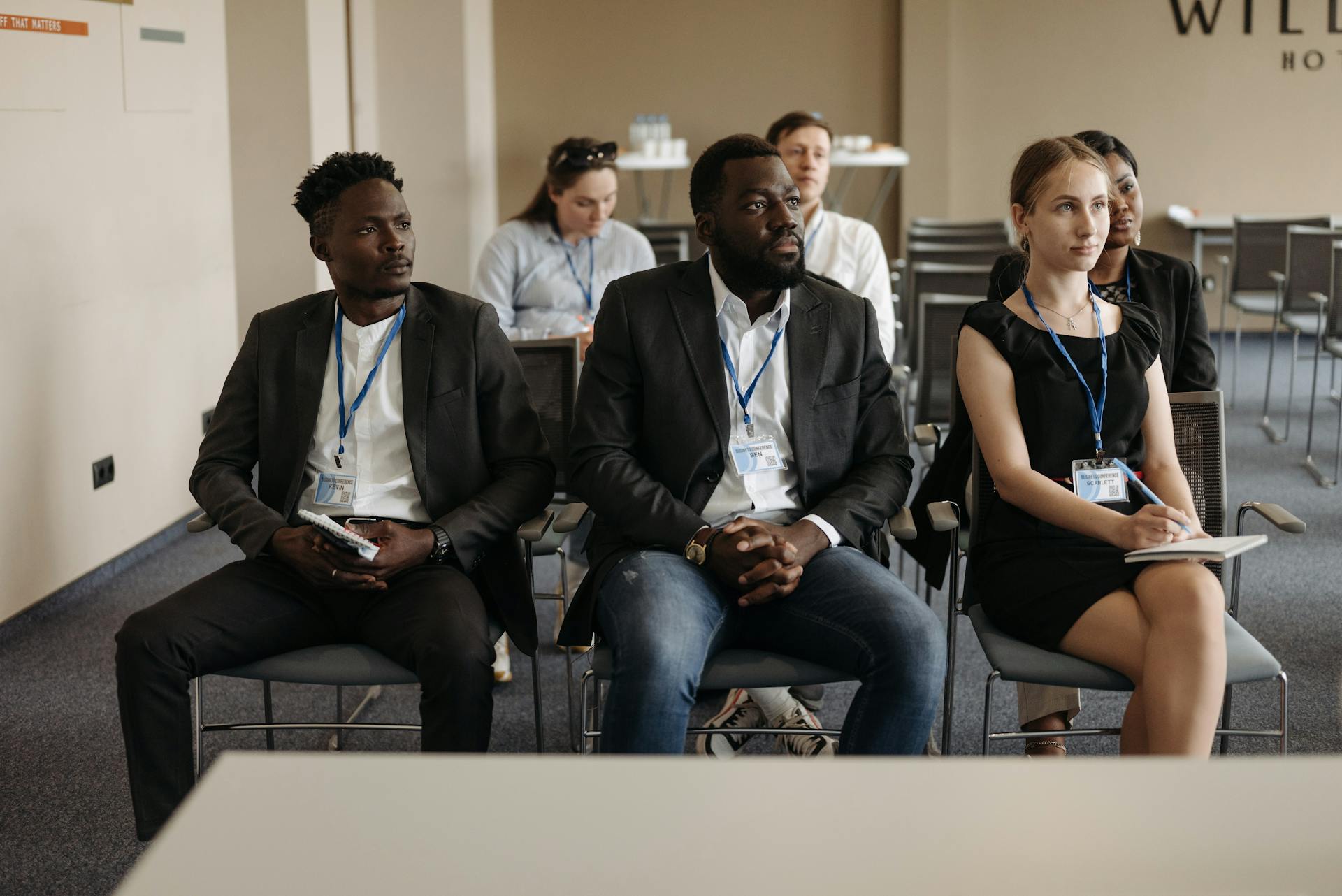 A diverse group of professionals attentively listening during a business seminar in a conference room.