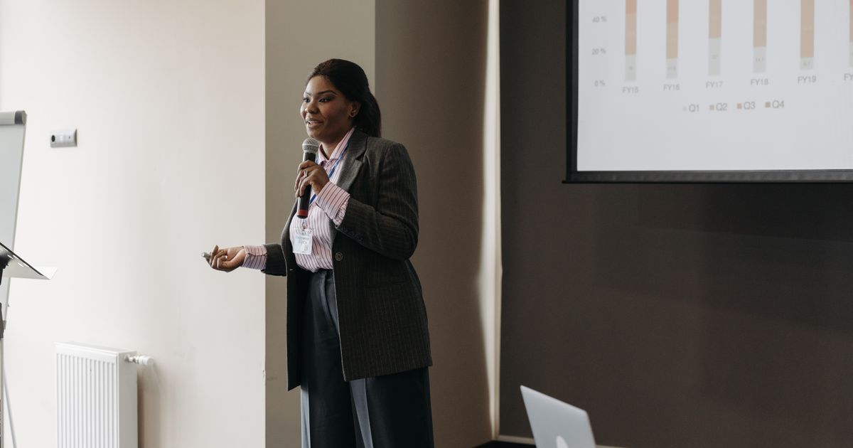 A successful UK entrepreneur sharing her journey with a captivated audience in a seminar room.