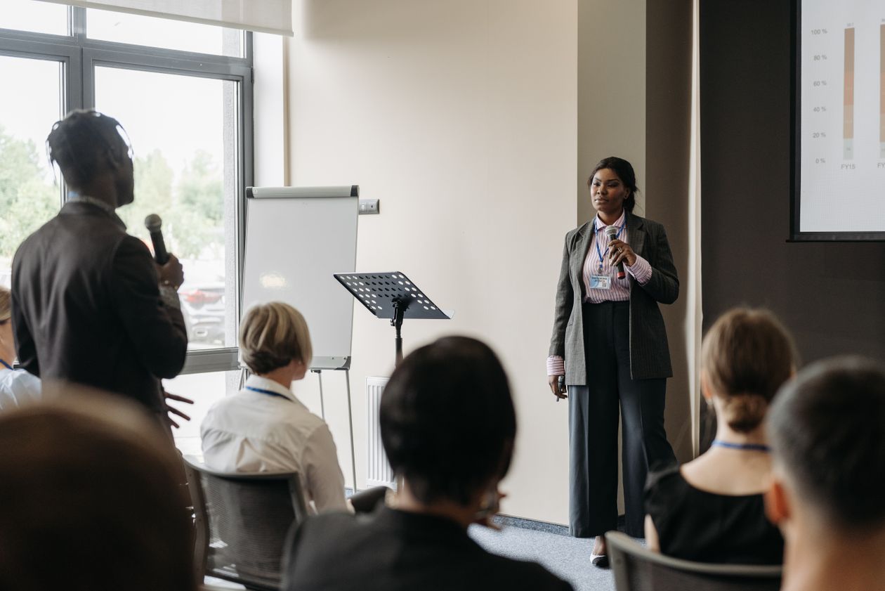 Professional business conference presentation with diverse participants engaging in communication