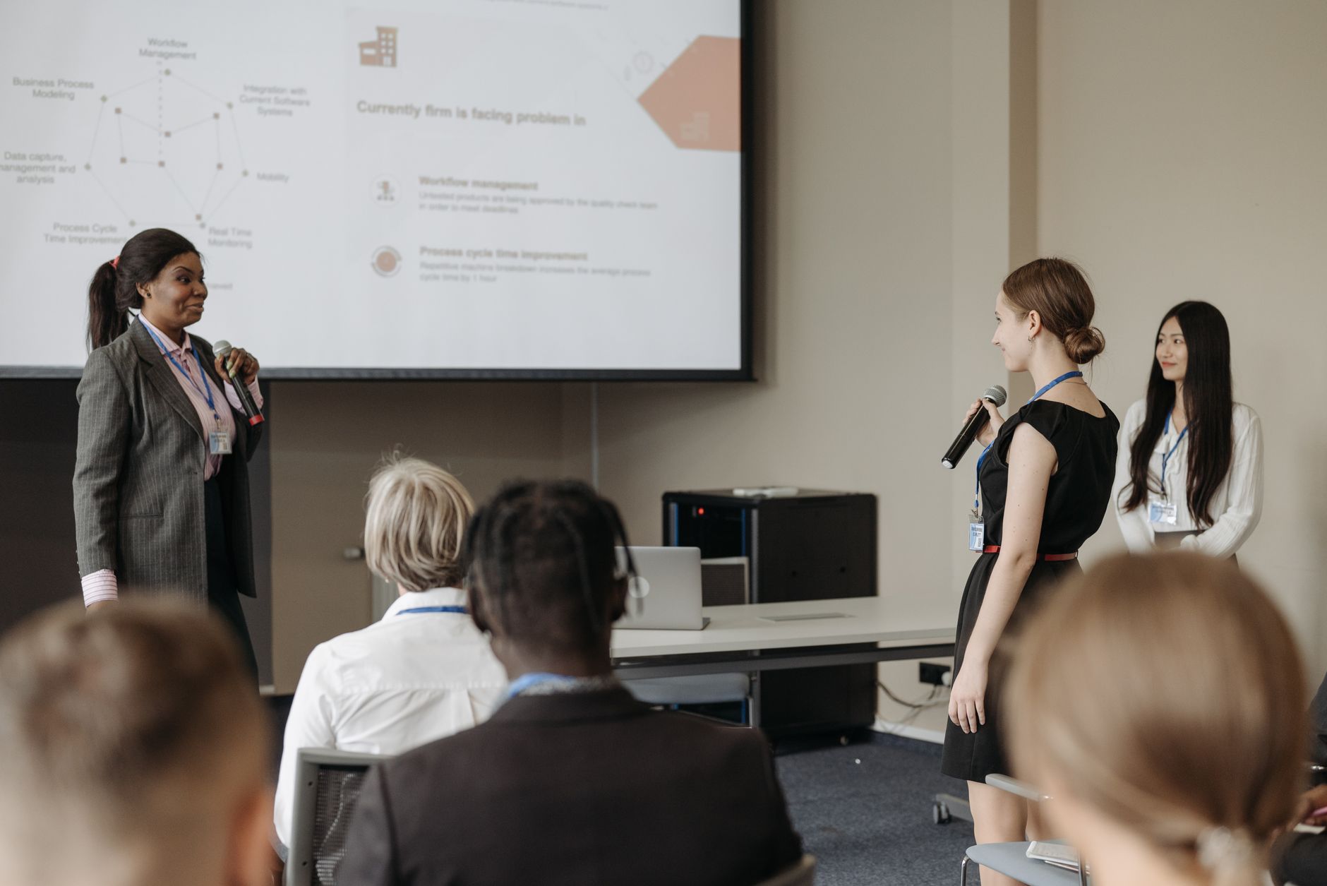 Corporate conference scene with women presenting and engaging audience involvement.