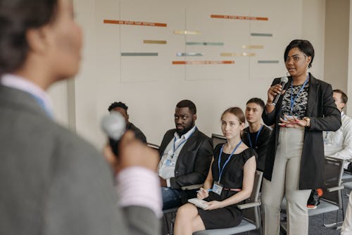 A Businesswoman Talking to a Speaker at a Business Conference