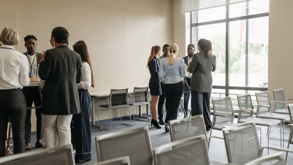 Professionals talking in small groups at a casual networking session