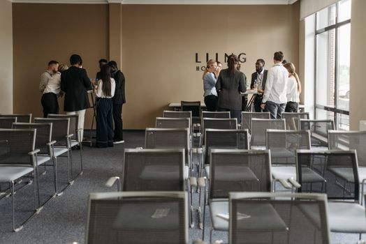 A group discussion taking place in a contemporary conference room with empty chairs.