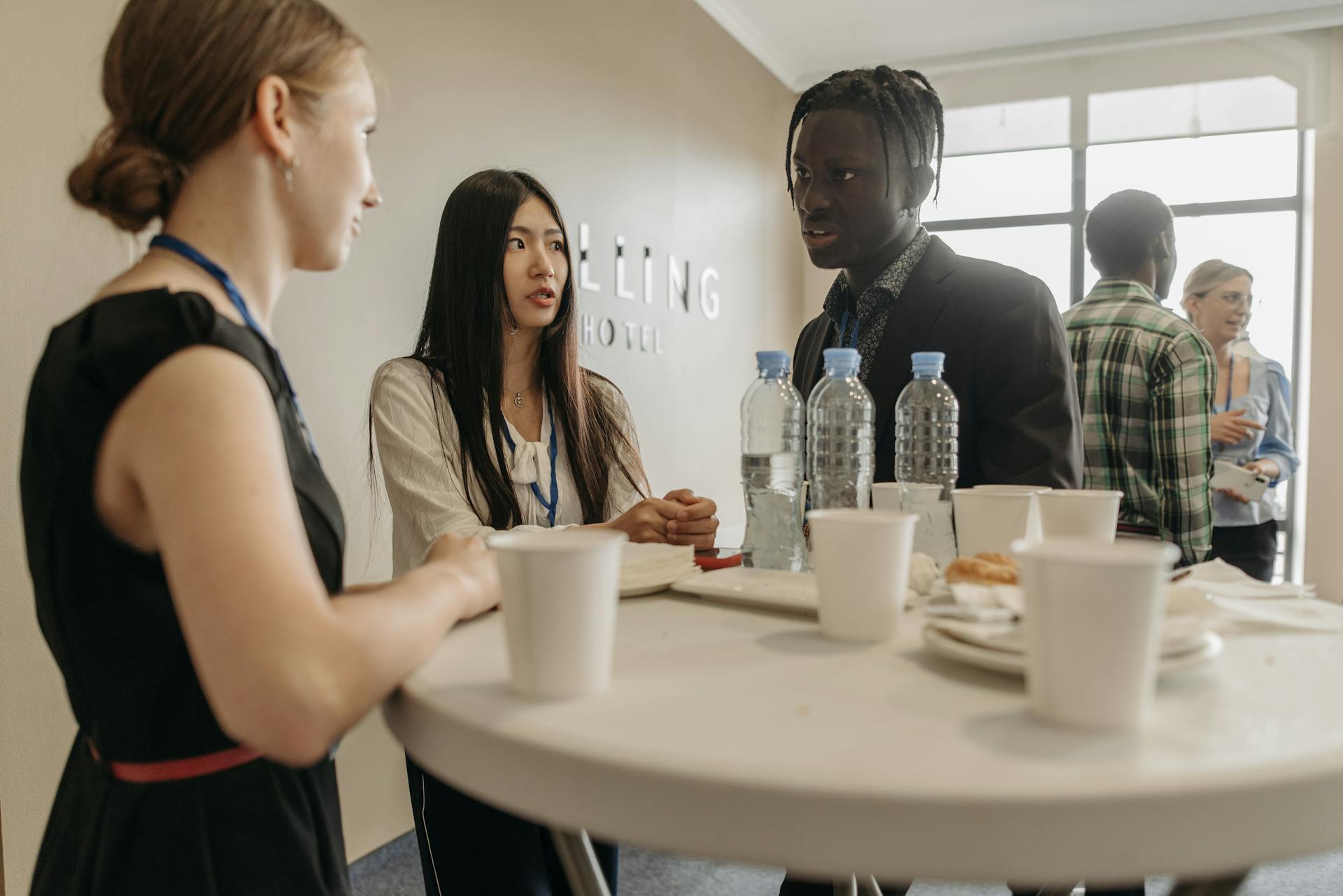 A diverse group of professionals networking at a business event with refreshments.