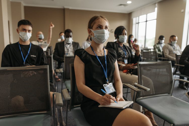 A Group Of People Taking Notes In A Conference Room