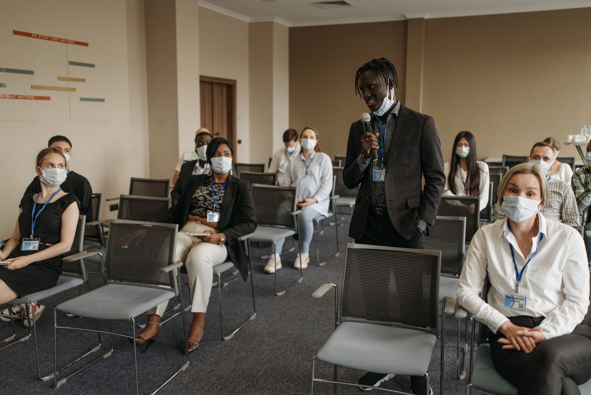 Business meeting with diverse participants wearing masks. Pandemic safety protocols in a conference room.