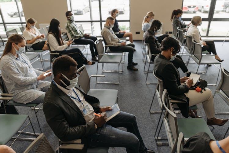 A Group Of People Taking Notes In A Conference Room