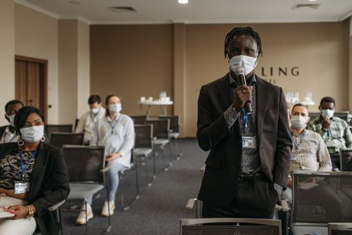 Free Business conference with participants wearing masks, discussing various topics while maintaining safety protocols. Stock Photo