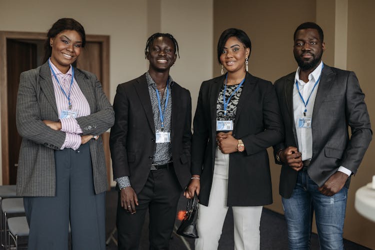 Group Of People Wearing Corporate Attire And Badge Smiling