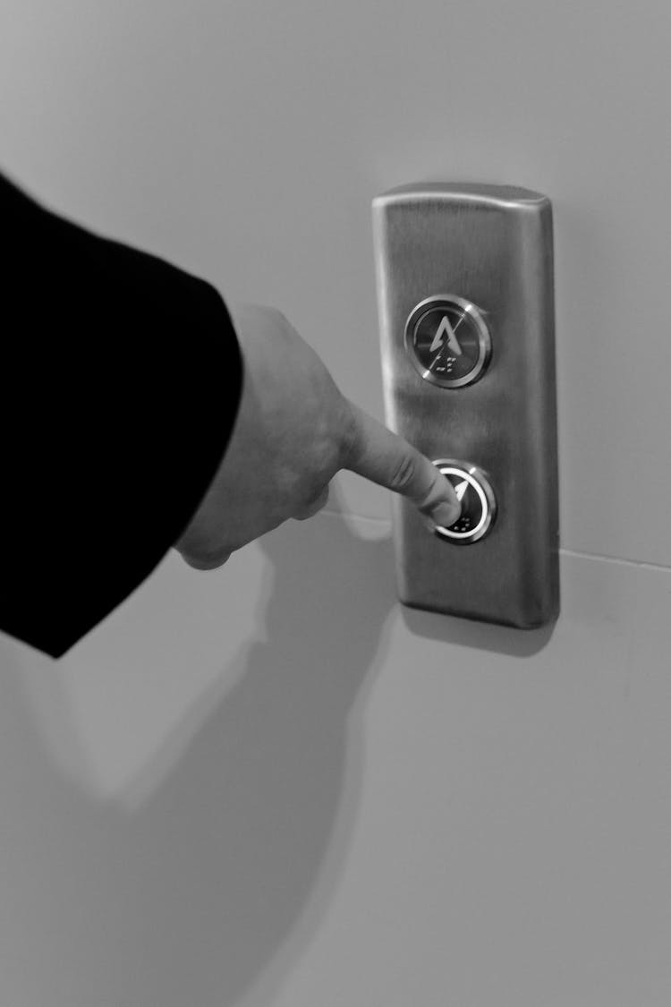 A Person Holding Stainless Elevator Button