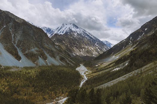 Spectacular aerial view of snow-capped mountains and river valley in Russia's Altai region.