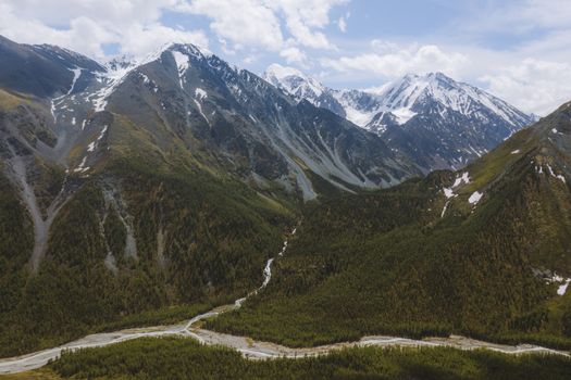 A breathtaking aerial view of the snow-capped Altai Mountains and lush valleys in Russia.