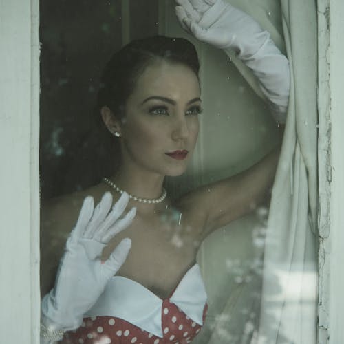 A Woman in White Gloves Behind the Glass Window