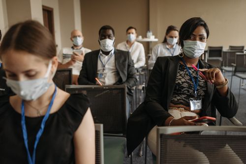 Free Business conference attendees wearing masks highlighting new normal and diversity in modern meetings. Stock Photo