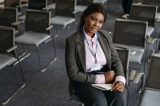 A Woman in Business Attire Sitting on a Chair inside a Conference Room