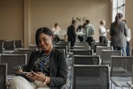 A Woman in Black Blazer Sitting on Gray Chair