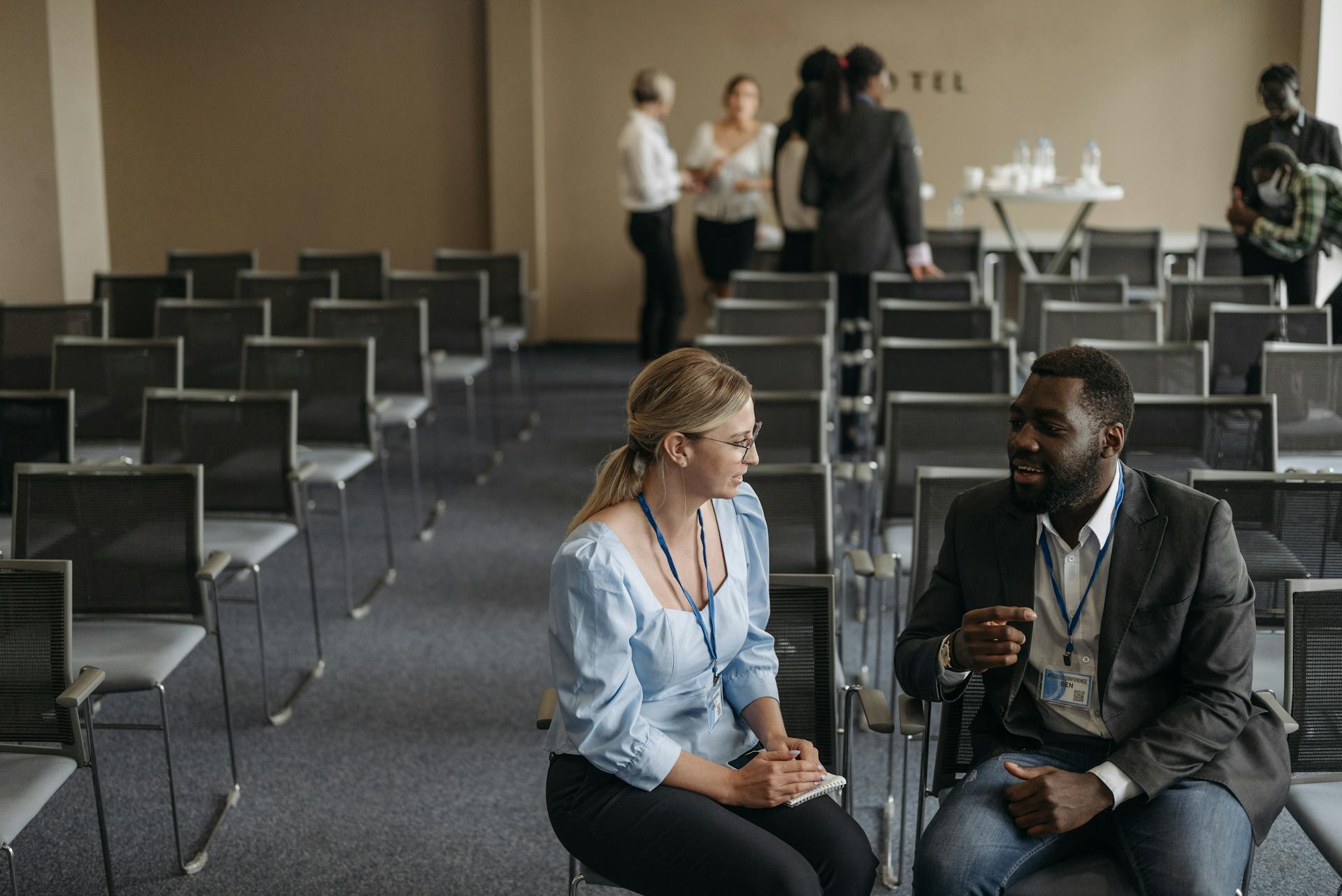 Business professionals having a conversation during a conference break, fostering communication.