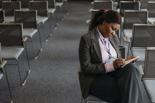 Professional woman writing notes in a quiet conference setting.
