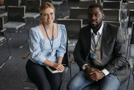 A man and woman smiling in a conference room. Ideal for business themes.