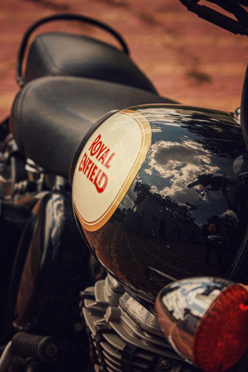 Free Detailed shot of a Royal Enfield motorcycle with a reflective fuel tank outdoors. Stock Photo