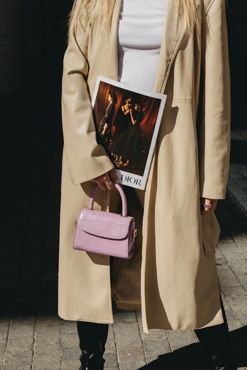 Person Wearing Long Coat and Holding Pink Mini Handbag