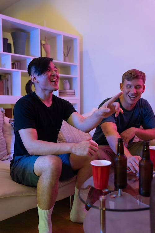 Men Sitting on the Couch while Having Fun