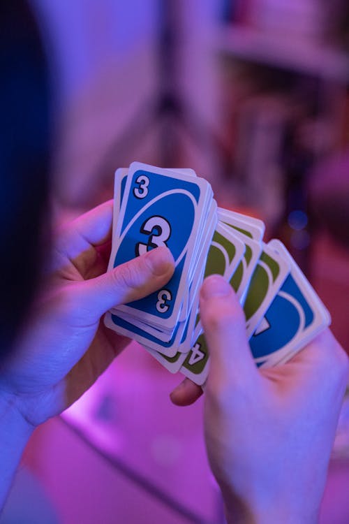 Free Close-Up Shot of a Person Holding Uno Cards Stock Photo